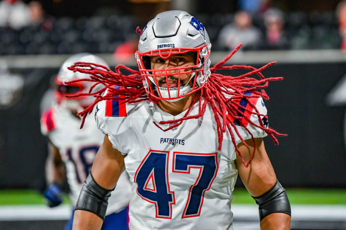 Jakob Johnson's red dreadlocks bounce during a pre-game warmup